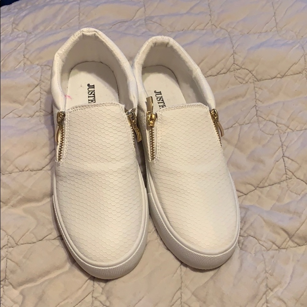 Slip on white zipper shoes.